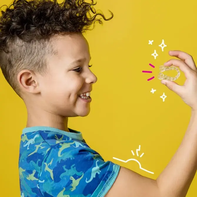 Child holding Invisalign First clear aligners - kohe™ Dental